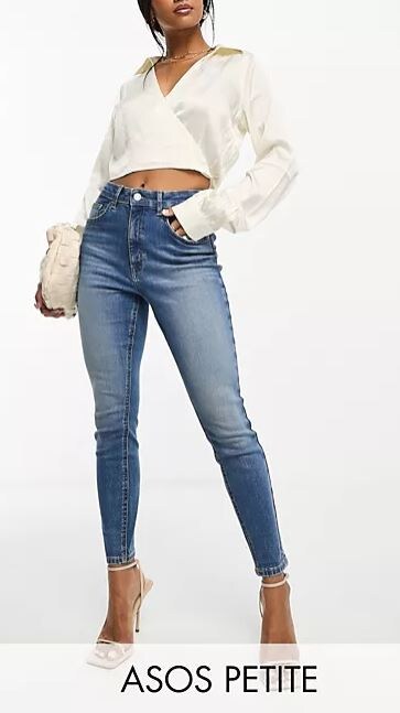 woman wearing white crop top shirt and blue skinny jeans