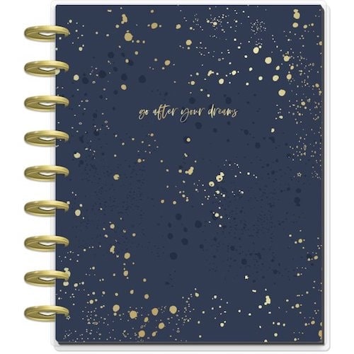 A Me & My Big Ideas Classic Guided Journal with gold clip binding that says “go after your dreams” on the navy and gold spotted cover