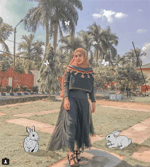Influencer Nabila Tarmuzi wearing tan hijab and dress with cartoon bunnies on grass