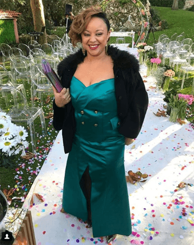Influencer Rose Palhares wearing teal strapless dress with slit in front with black fur jacket