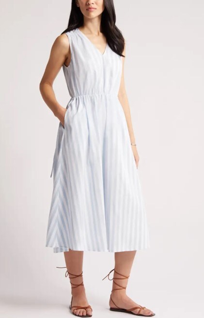 Model wearing Nordstrom’s Stripe Tie Waist Dress in white and light blue stripes, combined with brown flats