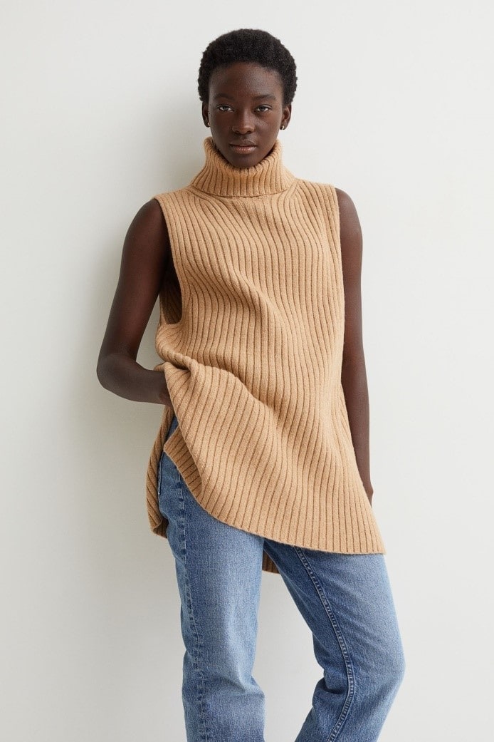 Model wearing the Loose Turtleneck Sweater Vest in dark beige, combined with bright-blue, loose-fit jeans