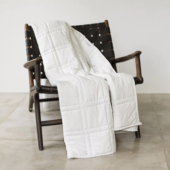 Baloo weighted throw blanket in white on a vintage armchair