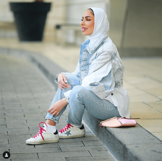 Fashion, lifestyle, and beauty influencer Fatema Al Awadhi sitting on a curb