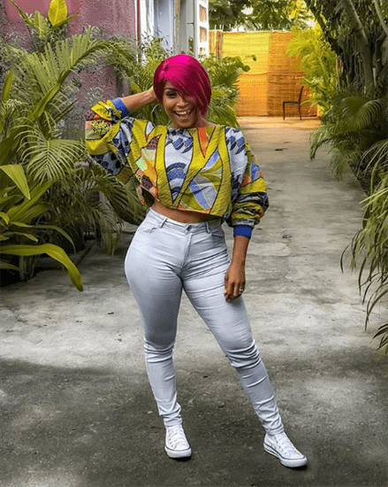 Mozambique singer and influencer Neyma posing in white jeans and multicolored top 