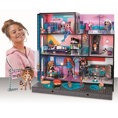 Smiling girl playing with LOL Surprise real wood dollhouse