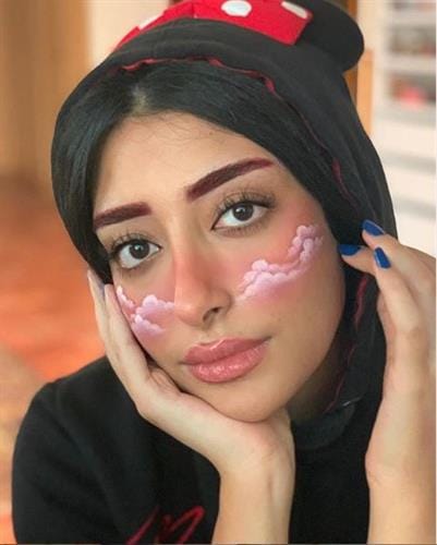 Bahraini pro makeup artist and influencer Fatema AlMuhana with artistic clouds painted on her cheeks