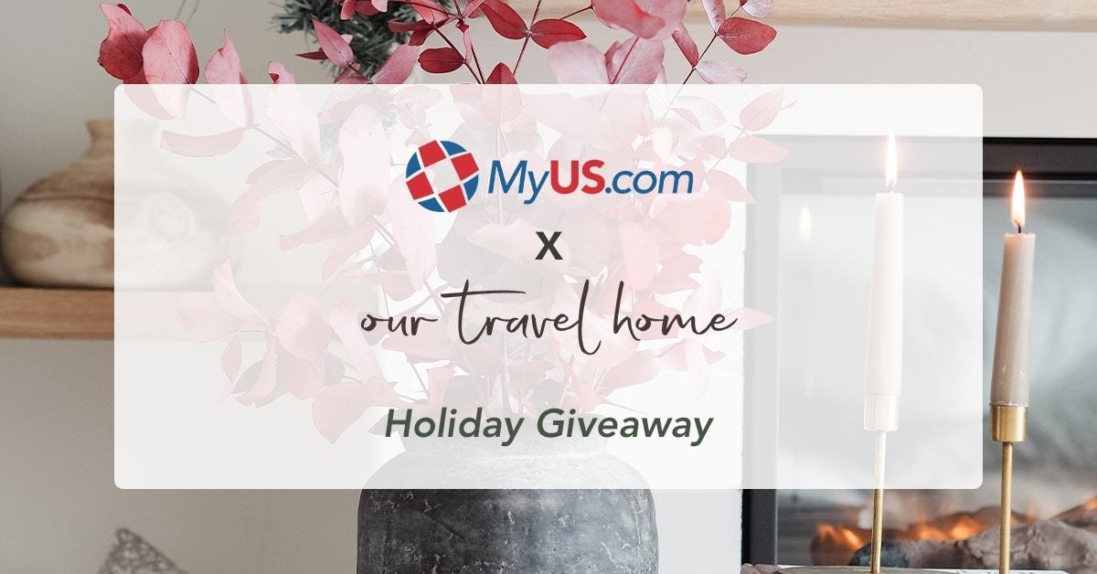 Vase of red foliage and lit candles on a tabletop with text "MyUS X Our Travel Home Giveaway"