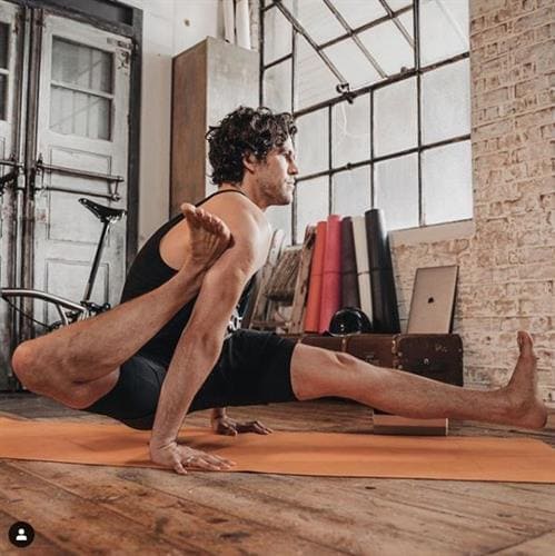 Influencer and yoga instructor Adam Husler in a yoga pose