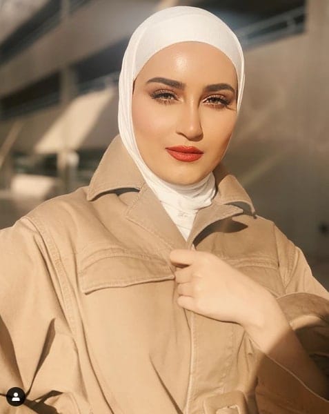 Dalal AlDoub in tan trench coat and white hijab