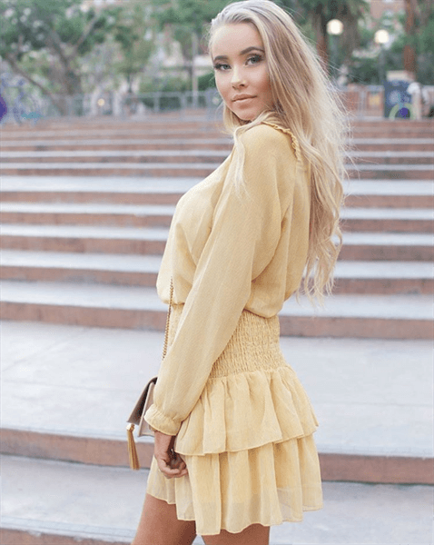 Influencer Martine Lunde Aarsrud posing in yellow sheer top and skirt on steps