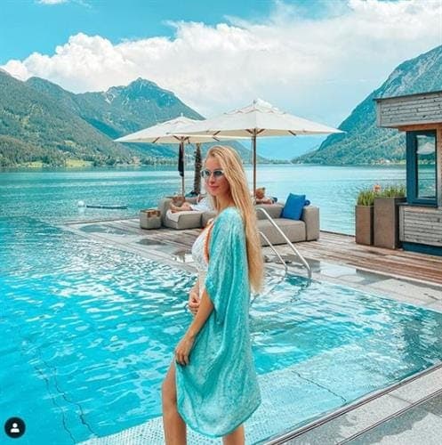German fashion influencer Viktoria posing in a blue coverup in front of a pool