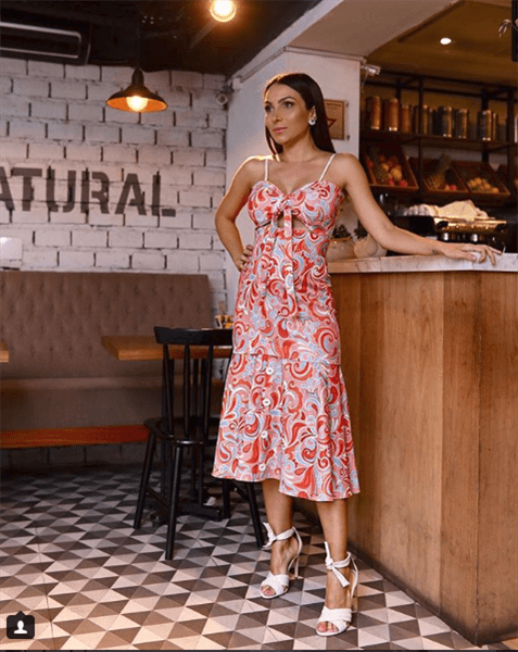 Influencer Lala Noleto wering red patterned dress in white lace up heels