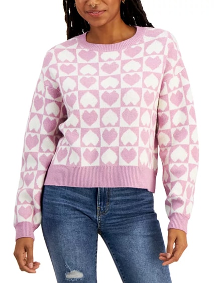 Model wearing a purple and white heart-print, ribbed-edge sweatshirt paired with dark blue jeans