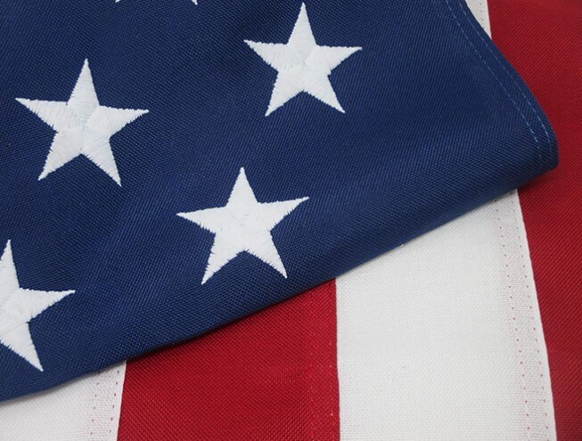 Close-up of a folded USA flag showing the red and white stripes and the blue rectangle with stars in the upper left corner
