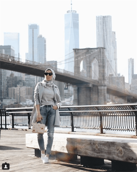 Blogger Melanie Elturk standing in front of Brooklyn Bridge wearing floral hijab