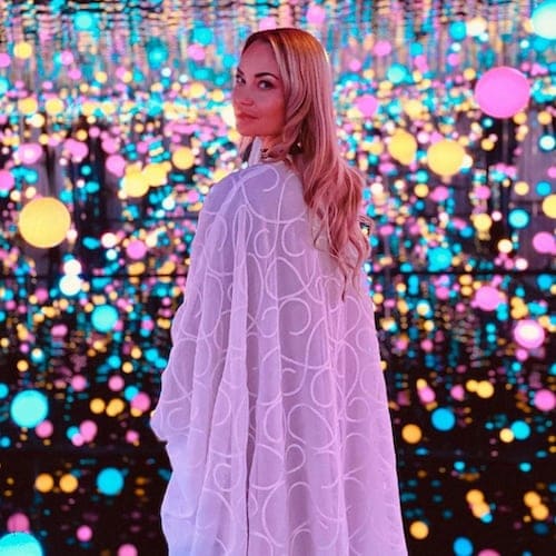 Laura Alho wearing a long white dress in the Infinity Mirrored Room inside the Maraya Concert Hall in AlUla