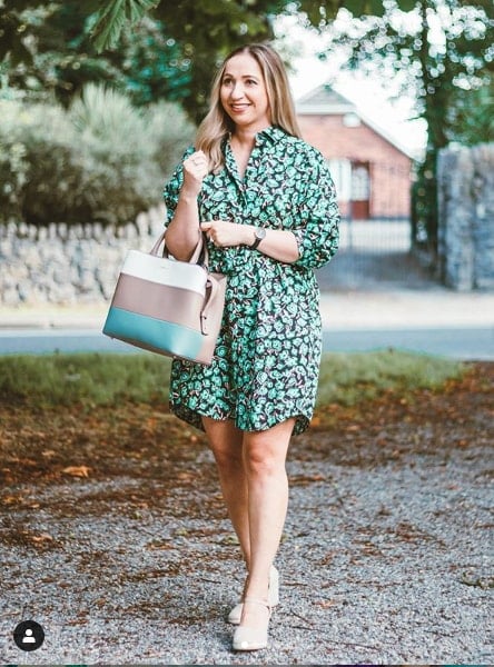 Andrea Opris posing with tote bag in a green dress