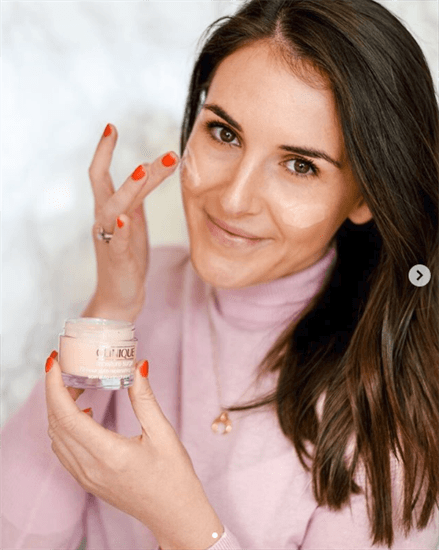 Influencer Victoria smiling while putting on Clinique cream on her face