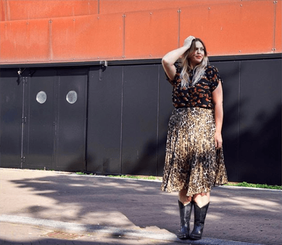 Influencer Edith Dohmen wearing patterned top and skirt with black cowboy boots