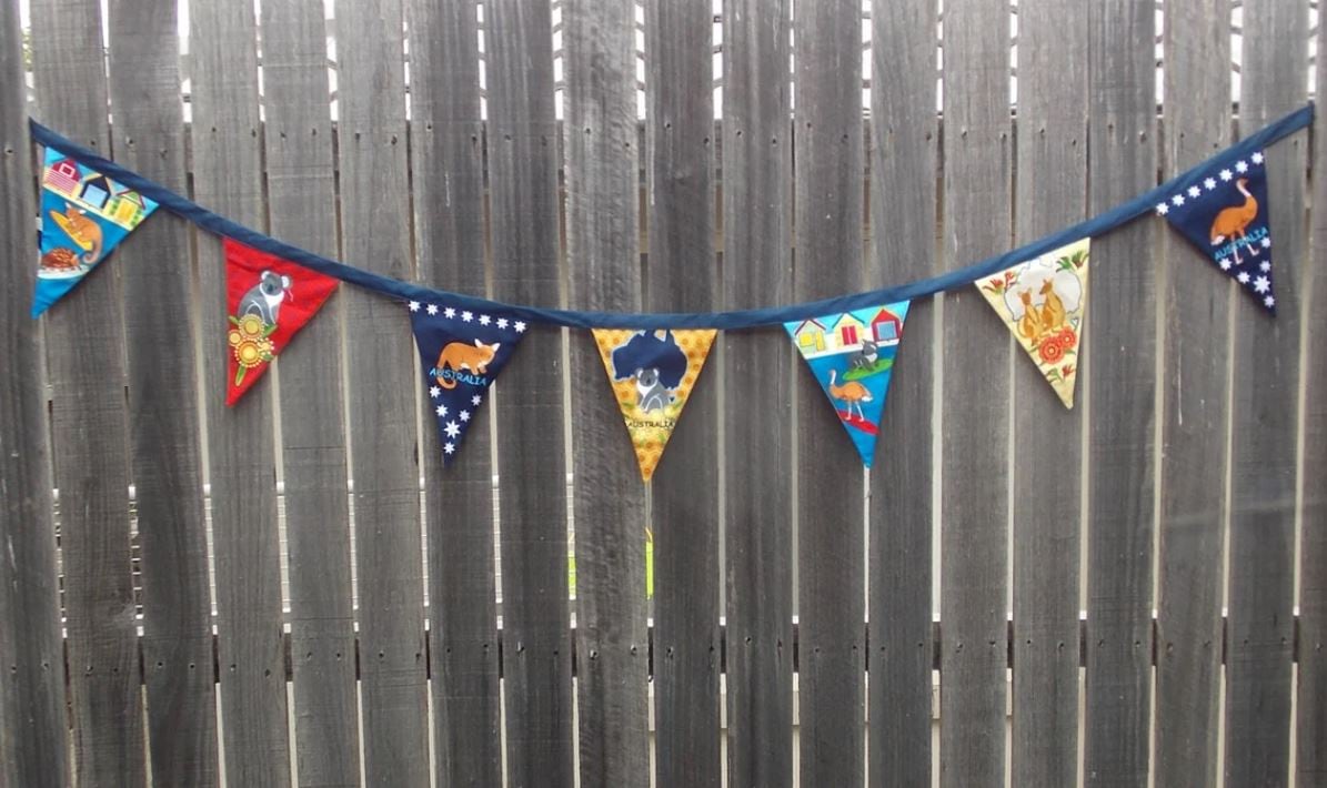 One blue and yellow SewCuteQuiltAndKnit Australia Day Bunting Picnic Decor Flag showing a grey and white Koala in front of a silhouette of Australia 