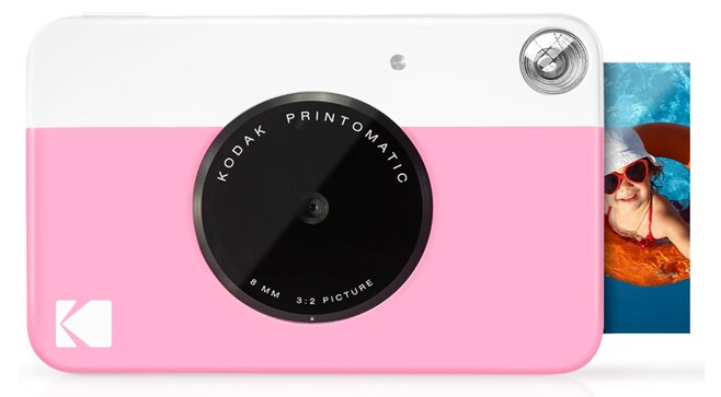 A pink and white KODAK instant print digital camera with a photo of a kid in a pool coming out of it
