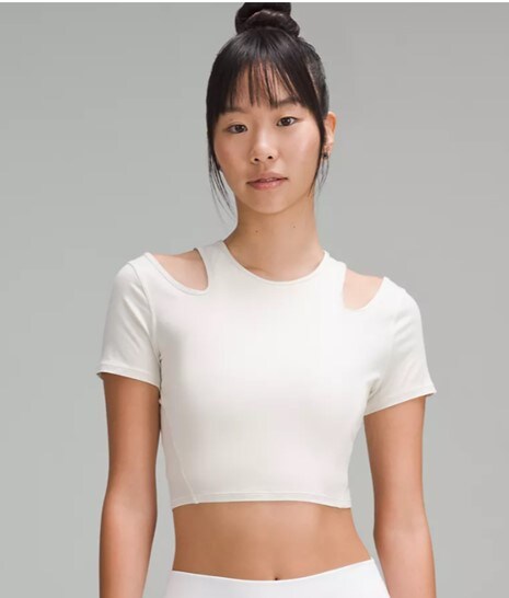 Model wearing a white shoulder cut-out yoga t-shirt