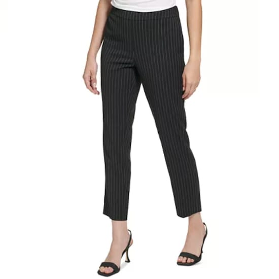 The lower view of a woman wearing a pair of black Calvin Klein Women’s Pinstripe Slim Leg Pants with thin white stripes and black open-toe heels