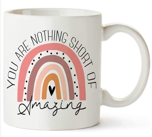 White mug personalized with a pink and purple rainbow-like print and the words “You Are Nothing Short of Amazing” over and under the print