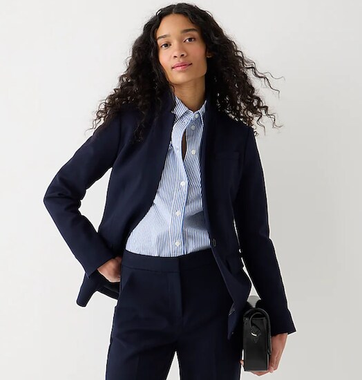 A woman wearing a navy J.Crew Regent Blazer in Four-Season Stretch with a blue striped shirt and navy pants