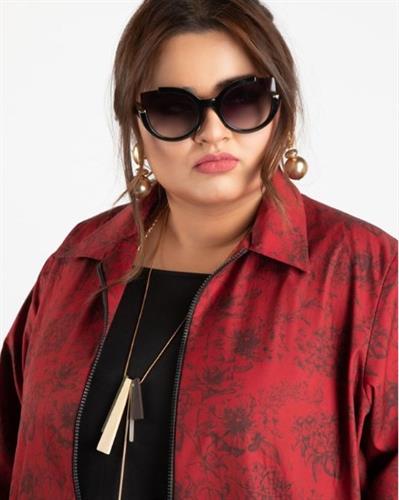 Pakistani actor and comedian Faiza Saleem striking a pose in sunglasses and a red blazer
