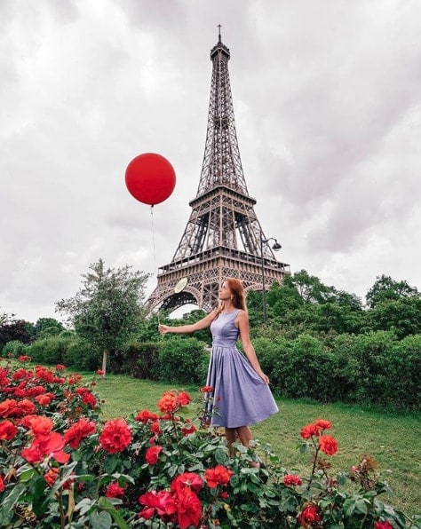Influencer Anna Karsten holding big red balloon with eiffel tower behind her