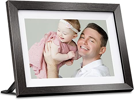 A wooden brown BIHIWOIA Digital Picture Frame showing off a smiling family next to a smartphone full of pictures