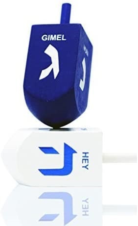One blue wood dreidel with the symbol gimel showing and one white wood dreidel with the symbol hey showing