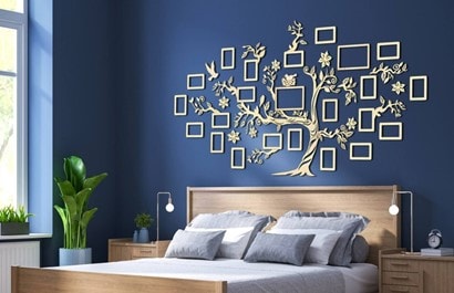 A navy bedroom wall decorated with wooden family tree picture frames